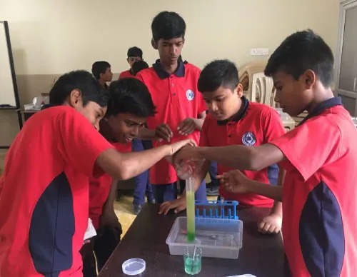 Friendly preschool teacher reading a picture book to attentive young children in a cozy corner